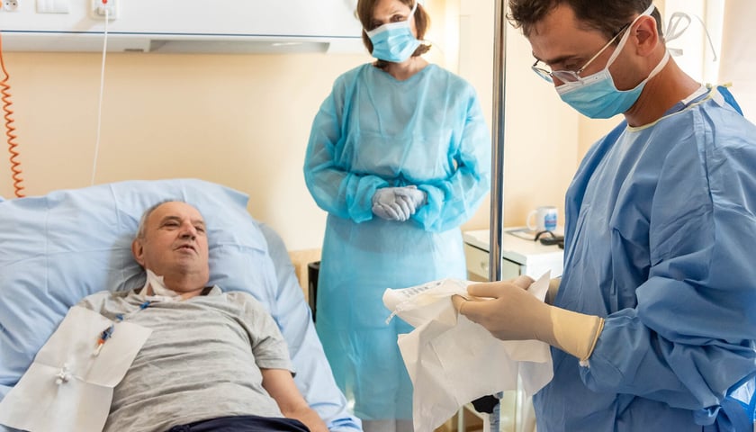 Lekarze przy łóżku pacjenta w klinice. Podanie komórek w ramach terapii CAR-T na chłoniaka w Klinice Hematologii UMW.