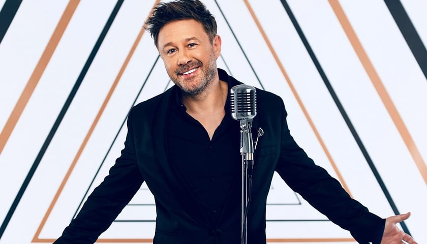 Andrzej Piaseczny. Na zdjęciu uśmiechnięty mężczyzna