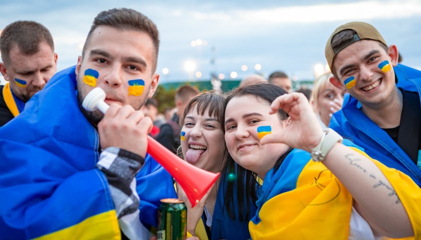 Grupa kibiców z flagami Ukrainy namalowanymi na policzkach w drodze na mecz Ukraina - Francja na Tarczyński Arenie