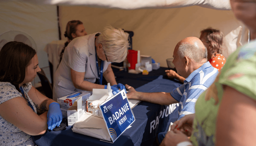 Kobiety i mężczyźni podczas badania krwi. Edycja Wrocławskich Dni Promocji Zdrowia w 2024 r. 