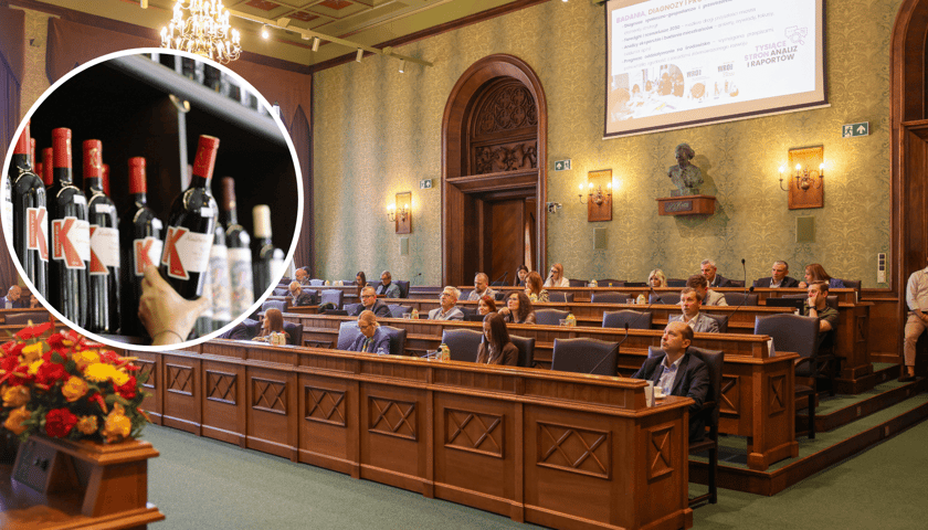 Radni podczas sesji rady miasta w Starym Ratuszu, w kółku ręka ściągająca z półki butelkę z alkoholem