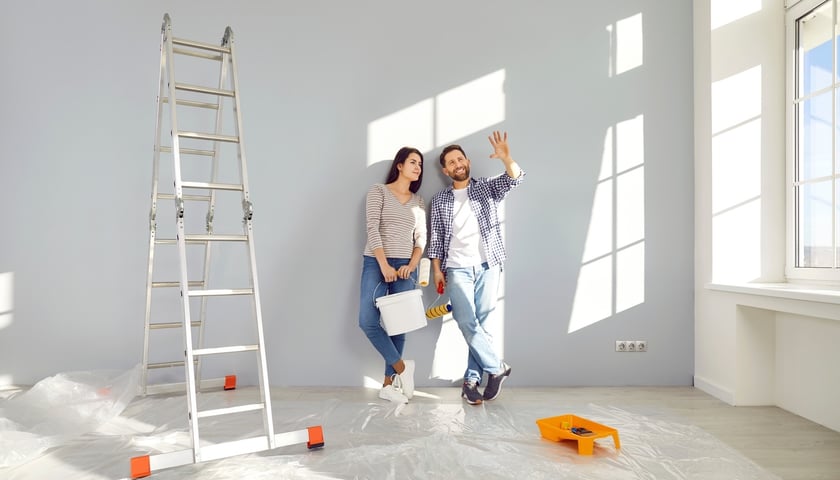 Kobieta i mężczyzna w mieszkaniu, w tle drabina i narzędzie do malowania, zdjęcie ilustracyjne