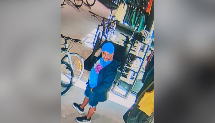 Mężczyzna w niebieskiej czapce z daszkiem w sklepie z rowerami (wizerunek podejrzewanej osoby)