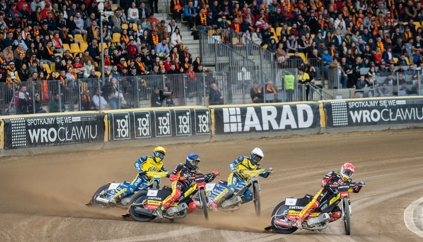 Dwóch żużlowców Betard Sparty i dwóch z GKM Grudziądz podczas wcześniejszego meczu na stadionie Olimpijskim. W tle wypełnione kibicami trybuny.