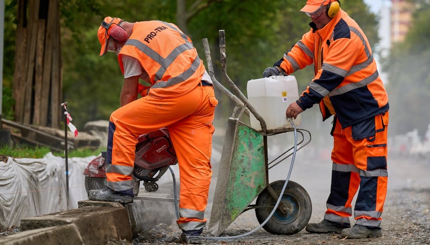 Dwójka robotników w pomarańczowych strojach na placu przebudowy Powstańców Śląskich, 15 września 2025