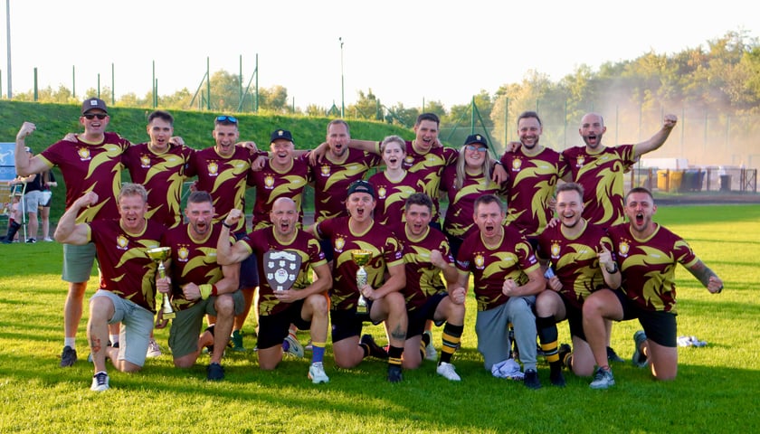 Radość drużyny Lions Wrocław po zdobyciu tytułu mistrza Polski sezonu 2025 w futbolu australijskim. Zawodnicy klęczą w przednim i stoją w tylnym rzędzie. Na ustach okrzyk "Hurraa!"