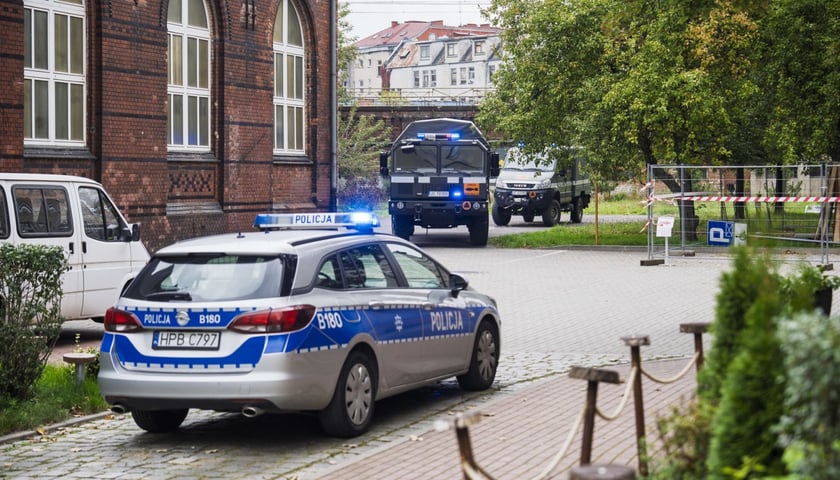 Akcja służb w Centrum Kształcenia Ustawicznego przy ul. Swobodnej. Na zdjęciu policyjny radiowóz i samochody saperów 