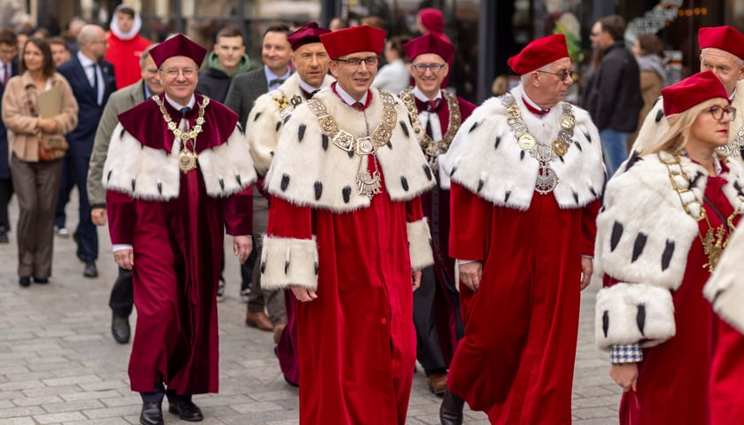 Na zdjęciu rektorzy w togach idą ulicą. Zdjęcie ilustracyjne