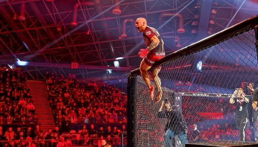 Zawodnik krzyczący w kierunku publiczności z siatki ringu, zdjęcie z poprzedniej gali Contra MMA w Orbicie