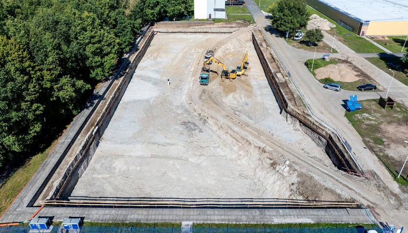 Widok wykopu z ciężarówkami i koparkami lotu ptaka. Budowa zbiornika wody w zakładzie "Mokry Dwór".