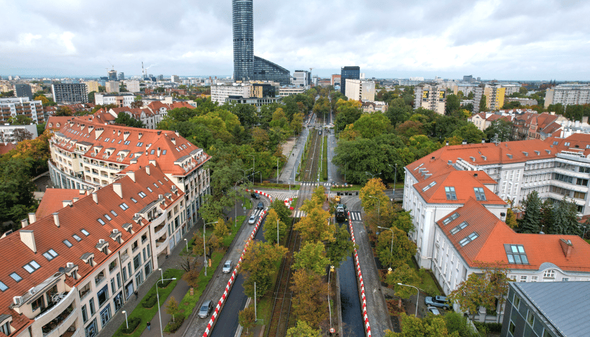 Przebudowa ul. Powstańców Śląskich z drona (9 października 2025). Widać asfaltową nawierzchnię na pasach lewych i brukową na prawych.