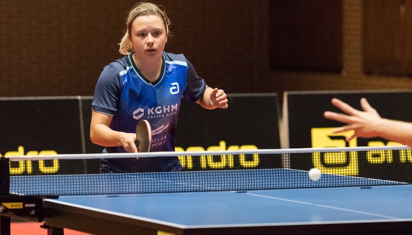 Zawodniczka AZS Uniwersytet Ekonomiczny Wrocław - Anna Węgrzyn, w czasie meczu tenisa stołowego z paletką w ręku. 