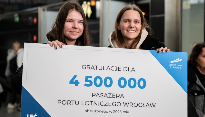 Dwie przyjaciółki z Poznania trzymające tablicę gratulacyjną z okazji rekordu frekwencji na lotnisku we Wrocławiu (Aleksandra po prawej stronie)