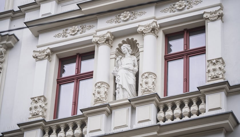 Okna w kamiennicy, figura w niszy na elewacji