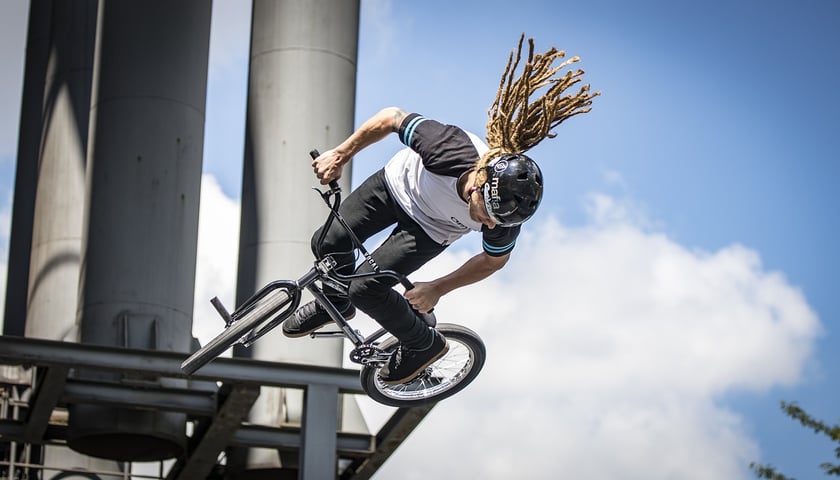 Osoba podczas ewolucji powietrznej na rowerze BMX (zdjęcie ilustracyjne)