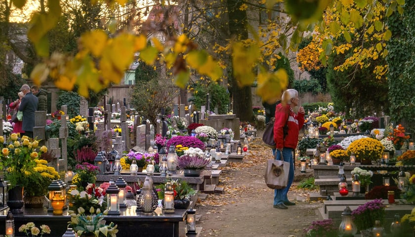Kobieta przy grobach na cmentarzu parafialnym św. Wawrzyńca (ul. Bujwida)