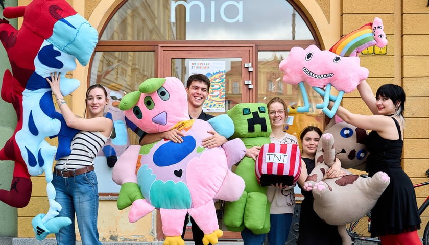 Studenci z Koła Naukowego DeForma wrocławskiej Akademii Sztuk Pięknych, którzy uszyli stworki zaprojektowane przez dzieci , w tle Mia Art Gallery na pl. Solnym we Wrocławiu