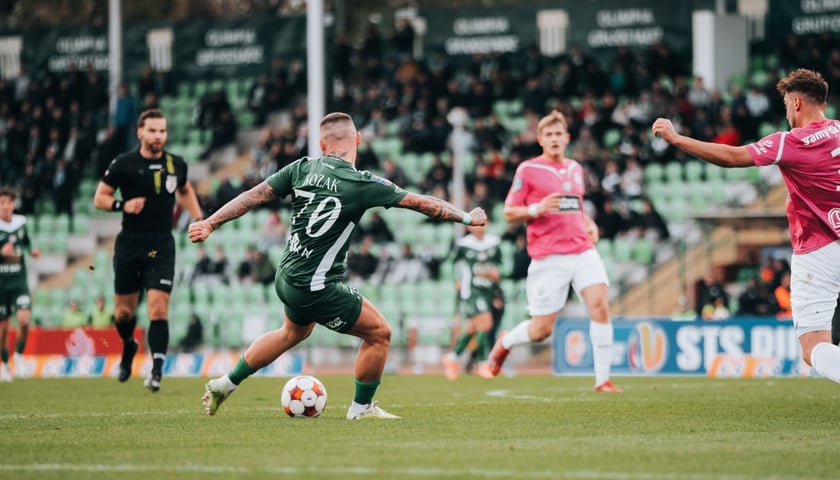 Piłkarze na boisku podczas meczu. Zawodnik Śląska Wrocław przy piłce.