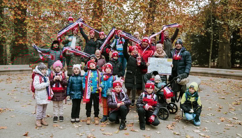 Zdjęcia z jednej z poprzednich edycji wydarzenia WrocWalk: grupa ludzi (w tym dzieci), w tle jesienny krajobraz