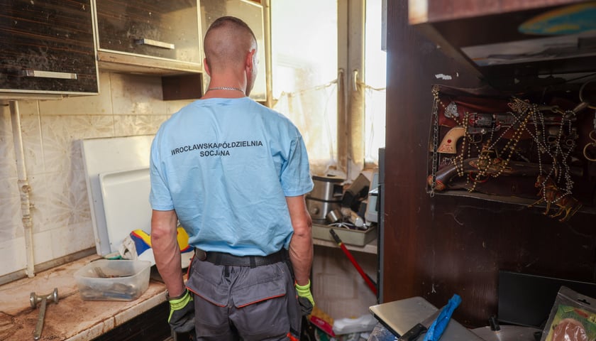 Pracownik Wrocławskiej Sp&oacute;łdzielni Socjalnej w trakcie sprzątania pustostanu