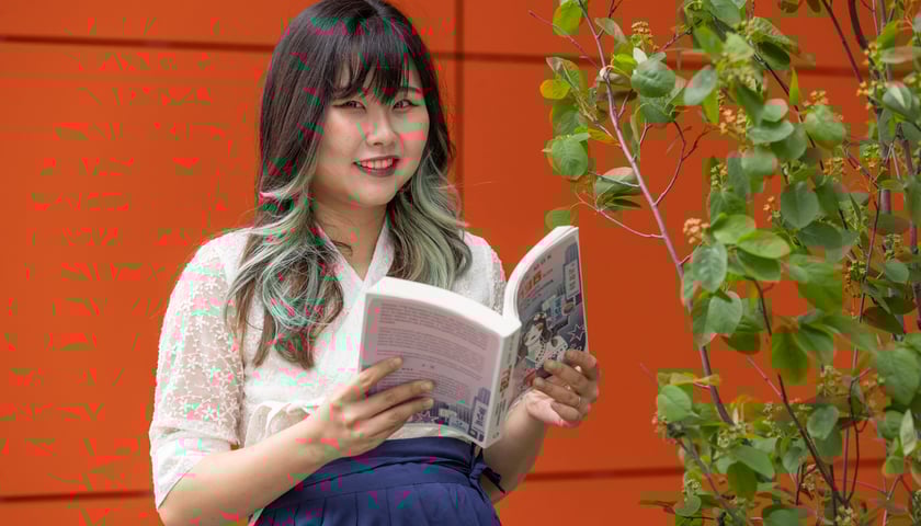 Mijin Mok z Uniwersytetu Wrocławskiego. Na zdjęciu młoda kobieta z książką