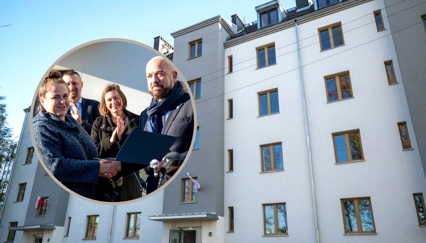 Jedna z nowych mieszkanek budynku przy ul. Wilczej odbiera klucze do mieszkania od prezydenta Wrocławia Jacka Sutryka, w tle wyremontowany budynek przy ul. Wilczej 1,3,5 na Przedmieściu Oławskim