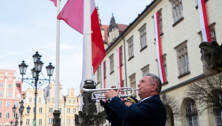 Podniesienie flagi państwowej na maszt w czasie uroczystości na wrocławskim Rynku