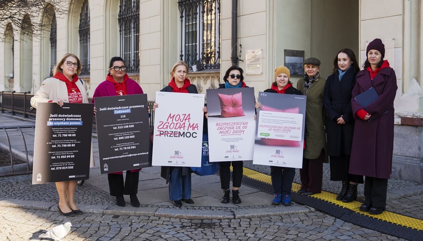 Zdjęcie po konferencji prasowej - grupa osób z transparentami pod Ratuszem