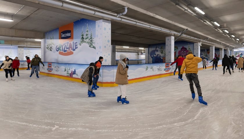 Grupa osób jeżdżących na łyżwach na lodowisku na Tarczyński Arena.