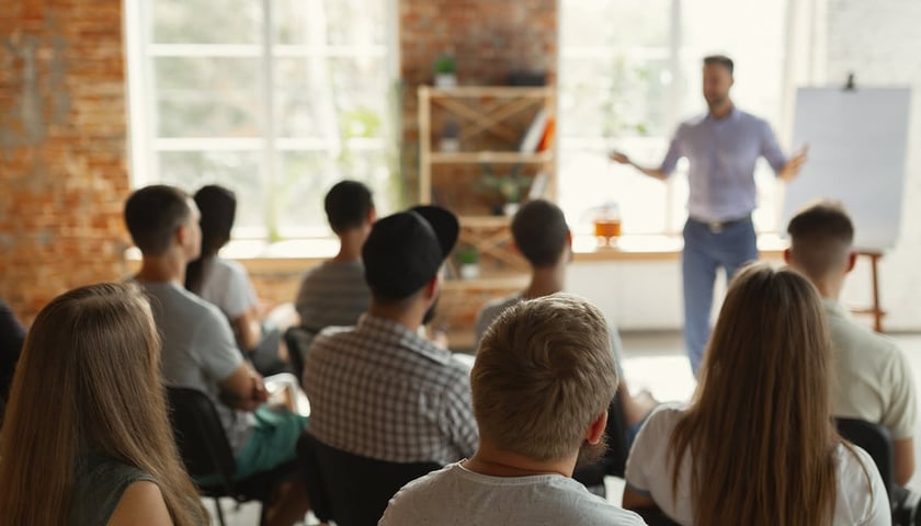 Grupa słuchaczy podczas szkolenia w sali konferencyjnej, zdjęcie ilustracyjne
