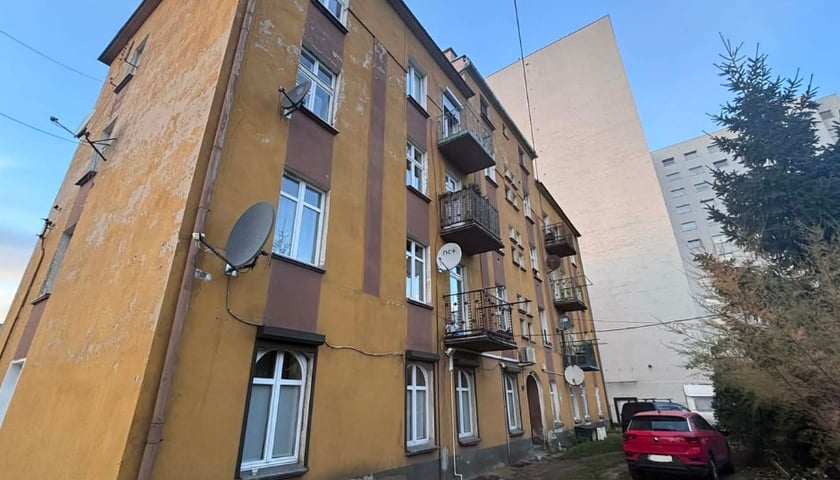 <p>Kamienica ukryta jest między nowoczesną architekturą</p>