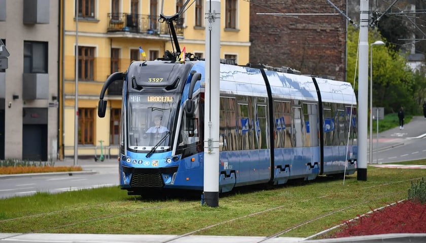 Niebieski tramwaj na zielonym torowisku we Wrocławiu, zdjęcie archiwalne na maja 2023 roku.