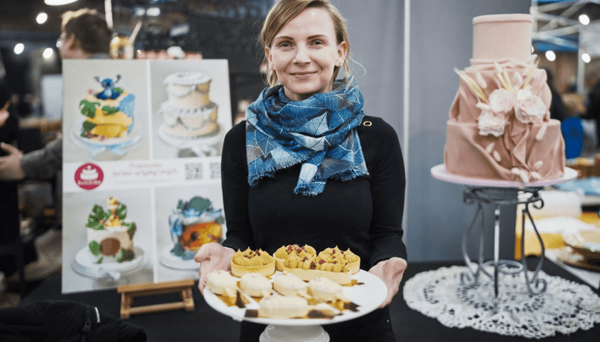 Kobieta trzyma talerz ze słodkościami podczas festiwalu Słodko-Gorzko w Czasoprzestrzeni we Wrocławiu