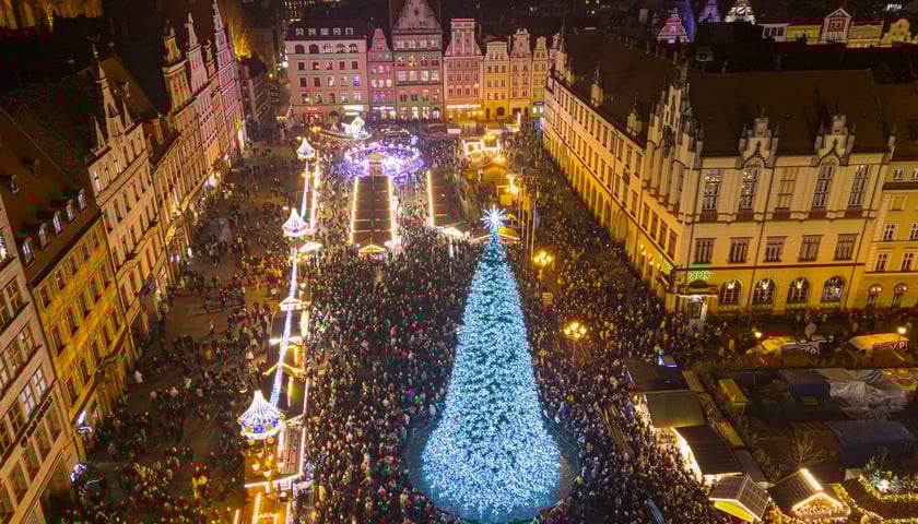 Tłum ludzi zgromadzonych wokół rozświetlonej choinki na Wrocławskim Rynku