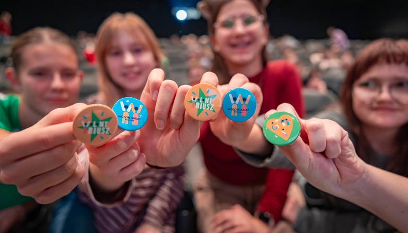 Młodzi wolontariusze pokazują przypinki w Nowych Horyzontach, 5 grudnia 2025