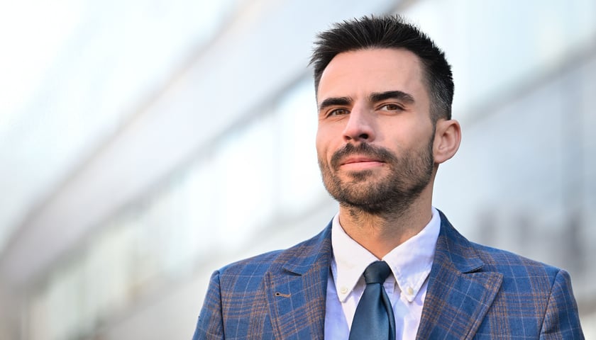 Dr hab. Sławomir Porada. Na zdjęciu młody mężczyzna w garniturze