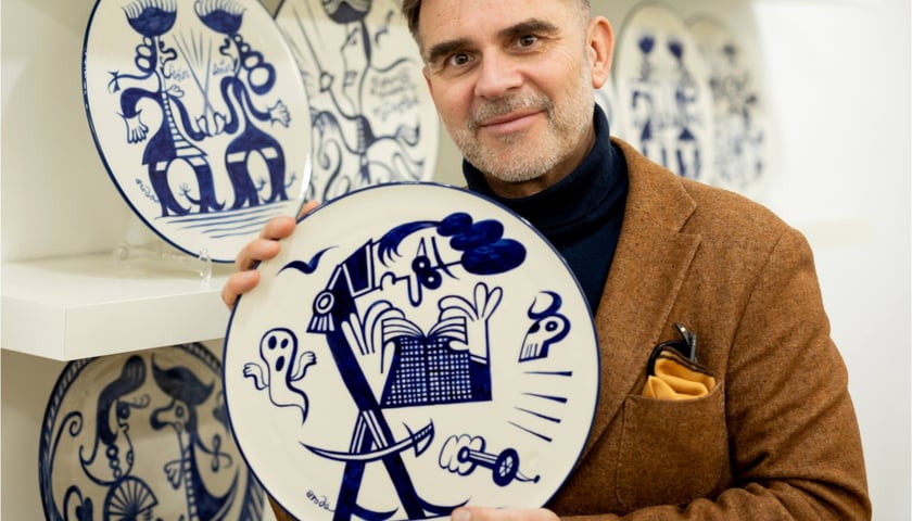 Tomasz Broda z wymalowanym przez siebie talerzem dla Ceramiki Bolesławiec