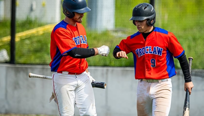 Dwóch zawodników grającej w baseball drużyny Barons Wrocław gratuluje sobie po zdobyciu kolejnych punktów w meczu.