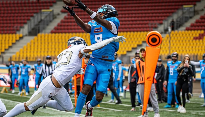 Zawodnik Panthers Wrocław łapie piłkę, atakowany przez gracza węgierskiego Fehervar Enthroners, podczas rozegranego na Stadionie Olimpijskim meczu ELF