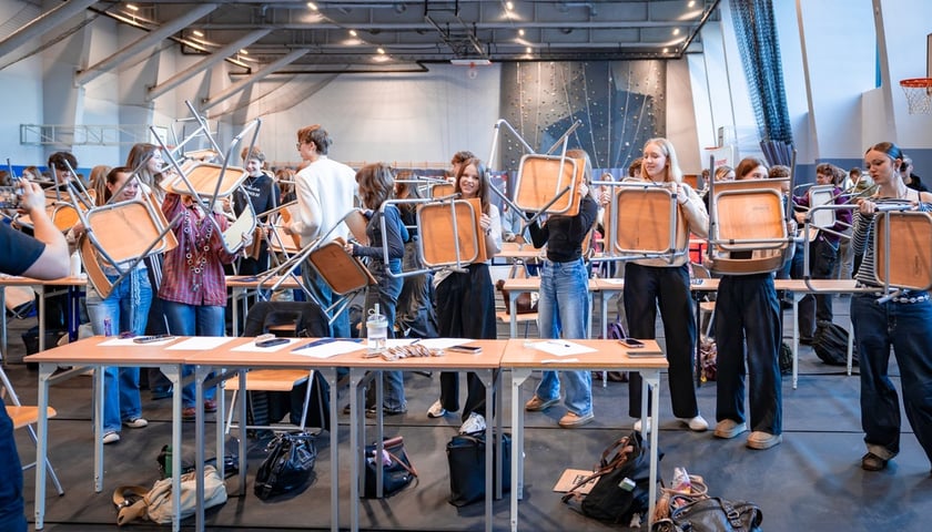 Dziewczyny i chłopcy z VLO przy ul. Kuronia w sali gimnastycznej podczas szkolenia Bezpieczny Wrocław pokazują, jak by się bronili krzesłami przed napastnikiem z nożem