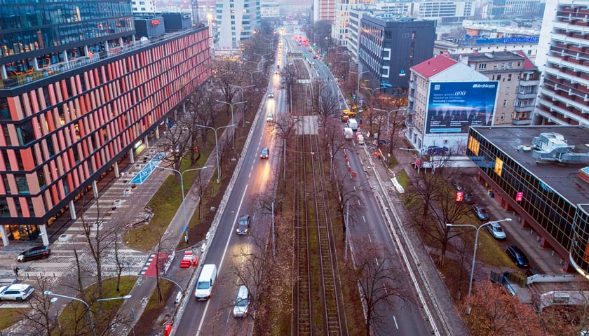 Widok z lotu ptaka na dwujezdniową ulicę, z torowiskiem tramwajowym po środku i budynki stojące przy niej. Wyremontowany fragment ul. Powstańców Śląskich.