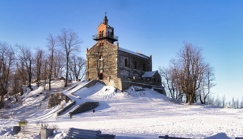 Kościół na szczycie Ślęży. Na zdjęciu widać ośnieżoną polanę i kamienny kościół w tle