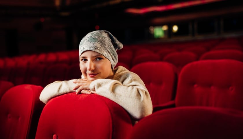 Emilka Wójcik. Dziesięciolatka wymyśliła akcję Postanawiam Pomagać!. Na zdjęciu uśmiechnięta dziewczynka na widowni teatru