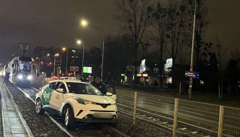 Taksówka Bolt na wydzielonym torowisku tramwajowym, w tle tramwaj. Zdarzenie drogowe na ul. Grabiszyńskiej.