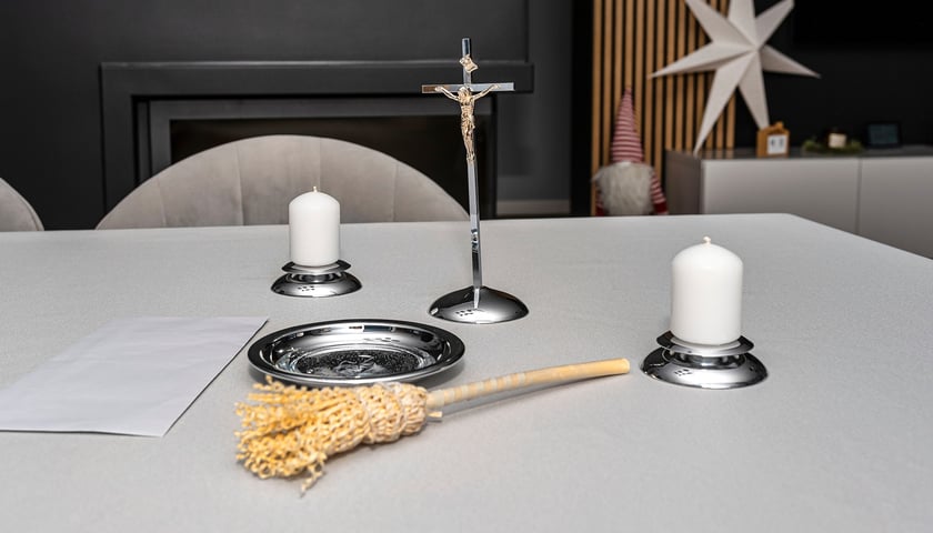 Na zdjęciu stół przygotowany na wizytę duszpasterską, na stole są krucyfiks, kropidło, świece. Zdjęcie ilustracyjne