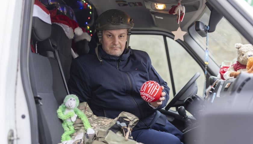 Piotr Kaszuwara w żołnierskim kasku, w samochodzie 