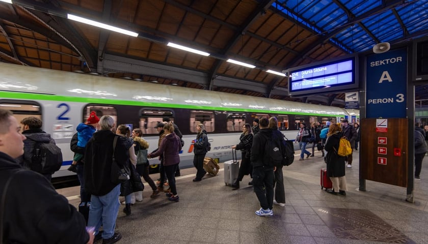 Ludzie na peronie czekają na wejście do wagonu kolejowego. Dworzec Główny PKP we Wrocławiu.
