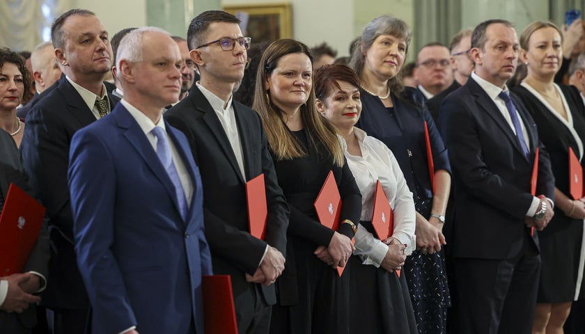W Pałacu Prezydenckim nominacje profesorskie odebrało 112 uczonych i artystów. Na zdjęciu grupa osób z dyplomami w czerwonych okładkach