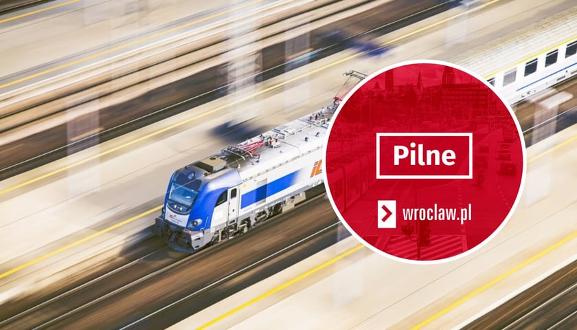 Pociąg osobowy w trakcie jazdy przez stację, widok z lotu ptaka. W kółeczku czerwona grafika z napisem "Pilne". Zdjęcie ilustracyjne