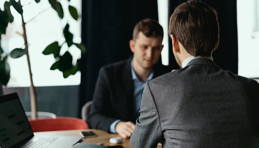 Dwóch mężczyzn przy stole, prowadzących negocjacje. Zdjęcie ilustracyjne